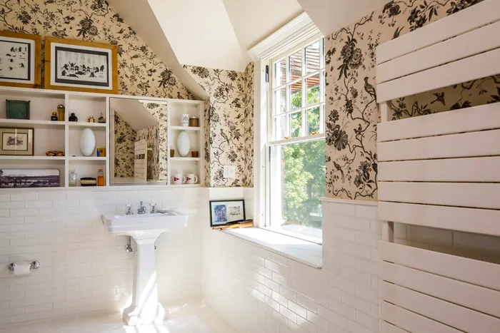 Bathroom with floral wallpaper, subway tile, and pedestal sink