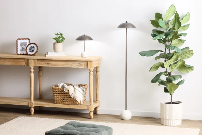 Dome table lamp and matching floor lamp, lit, styled on a console table with a potted plant
