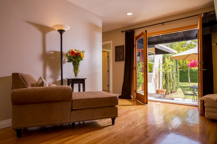 Living room with a chaise sofa opening onto a landscaped patio