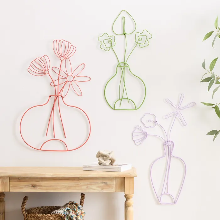 Three wire-outline vase-and-flower wall art pieces in coral, green, and lavender