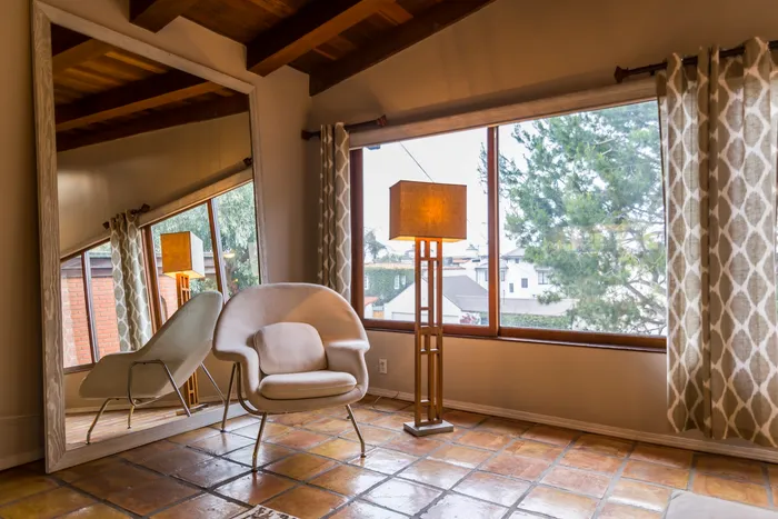 Sitting area with an oversized leaning mirror, accent chair, and lake view