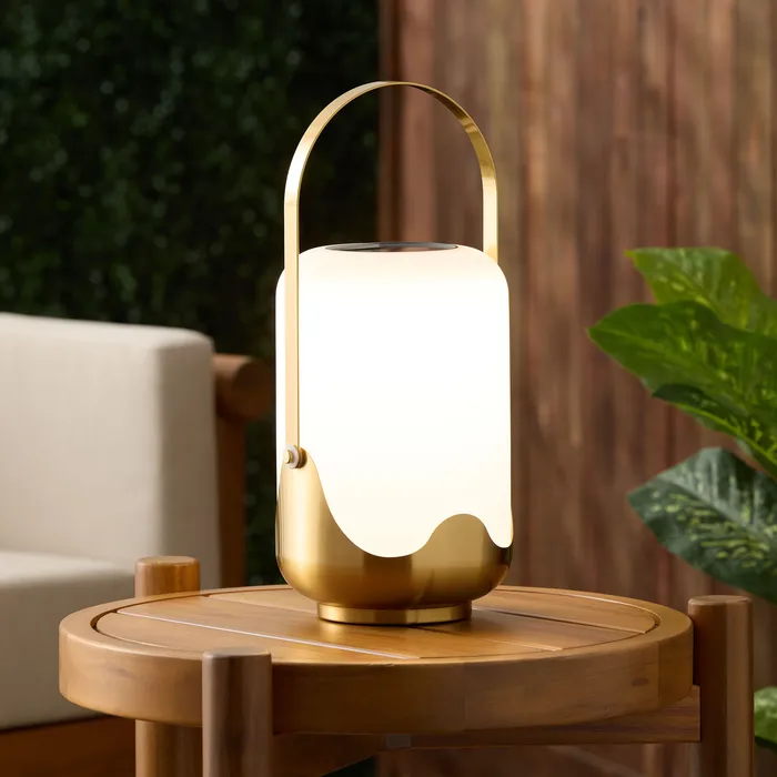 Dome table lamp and floor lamp styled on a console table with framed photos and a plant